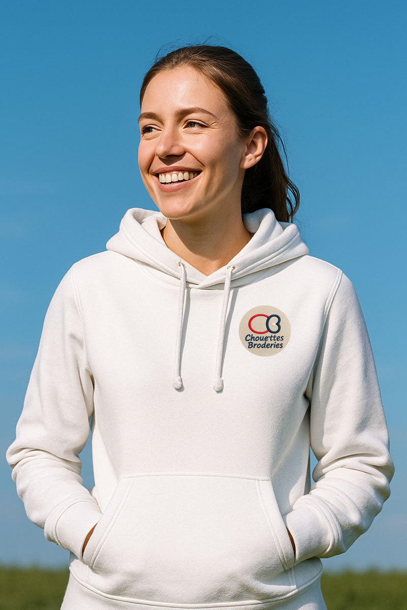 Femme souriante portant un sweat à capuche blanc dans un parc, par temps ensoleillé – illustration de la broderie personnalisée sur vêtement