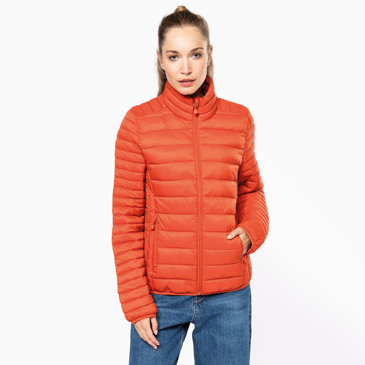 Femme portant une doudoune orange légère personnalisable avec logo brodé – Kariban K6121