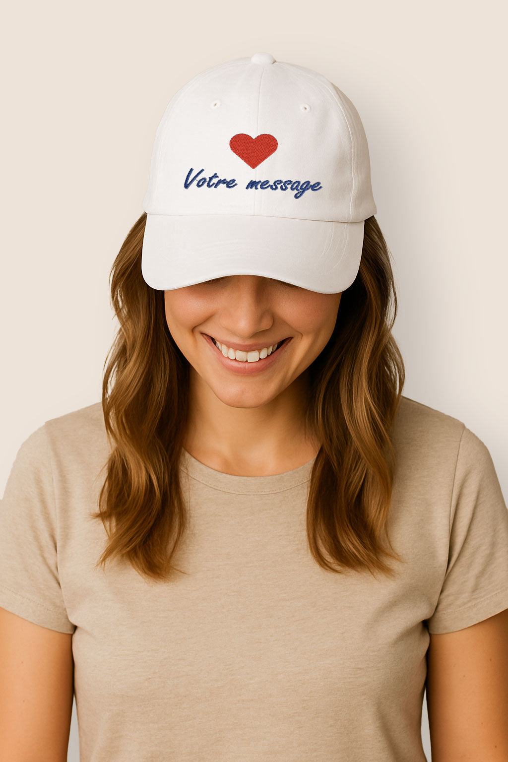 Femme souriante portant une casquette blanche personnalisée en coton brossé, avec broderie cœur rouge et message bleu.