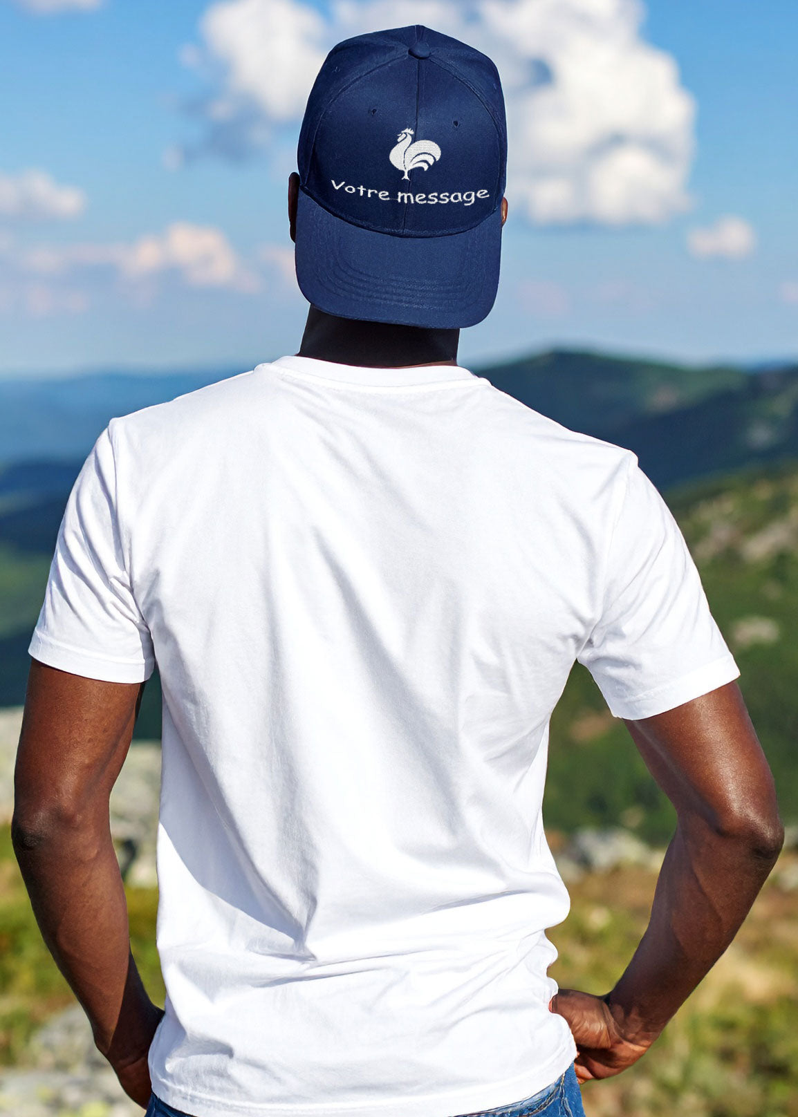 Homme de dos en t-shirt blanc et jean portant une casquette bleu marine personnalisée, avec broderie motif coq et message.