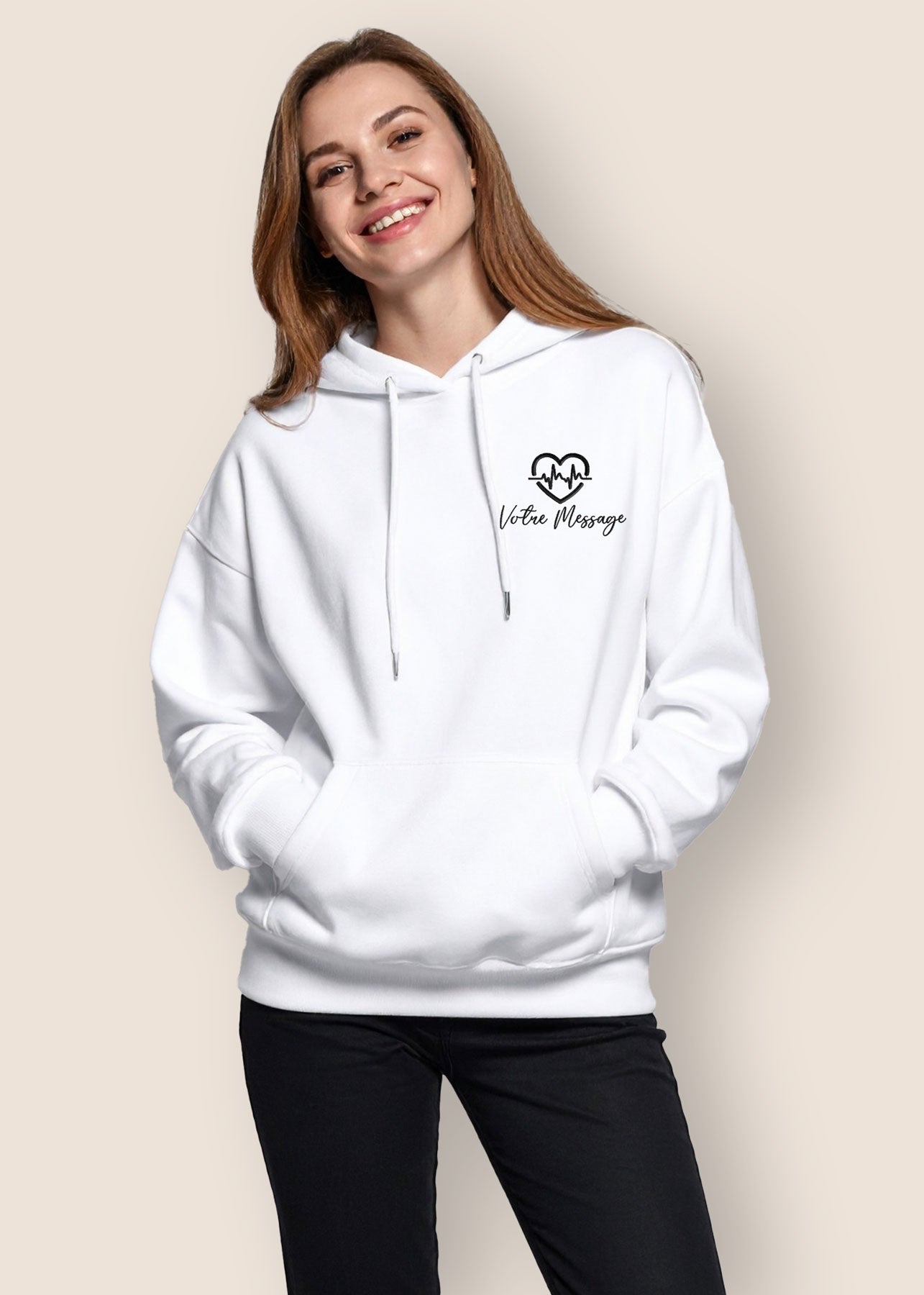 Femme souriante portant un sweat à capuche blanc avec broderie personnalisée "Votre message" et motif cœur avec électrocardiogramme, cadeau original pour femme.