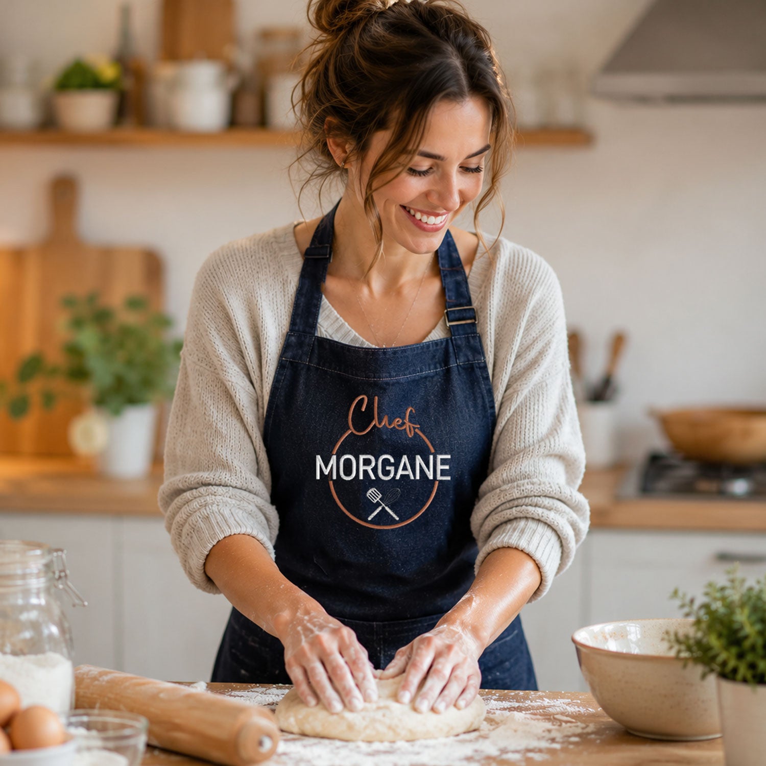 Femme portant un tablier de cuisine denim brodé Chef personnalisé au prénom Morgane, en train de cuisiner – Chouettes Broderies