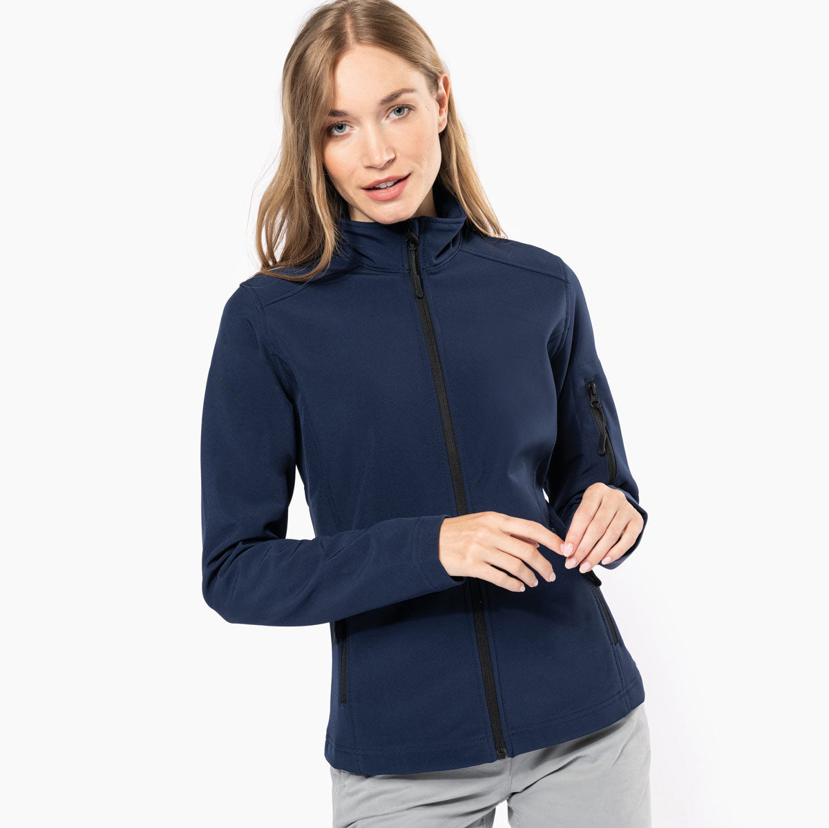Femme portant une veste softshell K400 marine, idéale pour la broderie personnalisée avec logo.