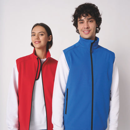 Homme et femme en gilets softshell sans manches brodés bleu roi et rouge, tenue d'équipe personnalisée IB413