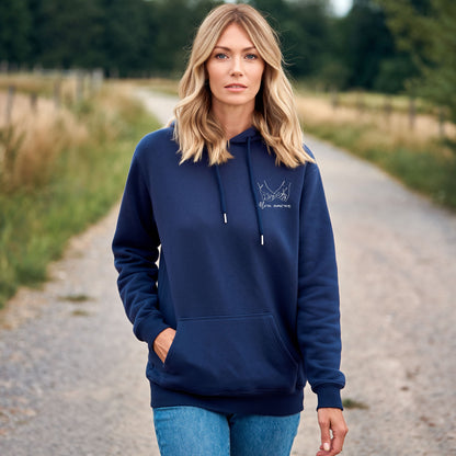 Femme portant un sweat à capuche bleu marine brodé avec motif mains entrelacées, sweat personnalisé pour couple, porté en extérieur dans un cadre naturel